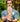 Man holding up a barefoot shoe with a grip sole with a forest background
