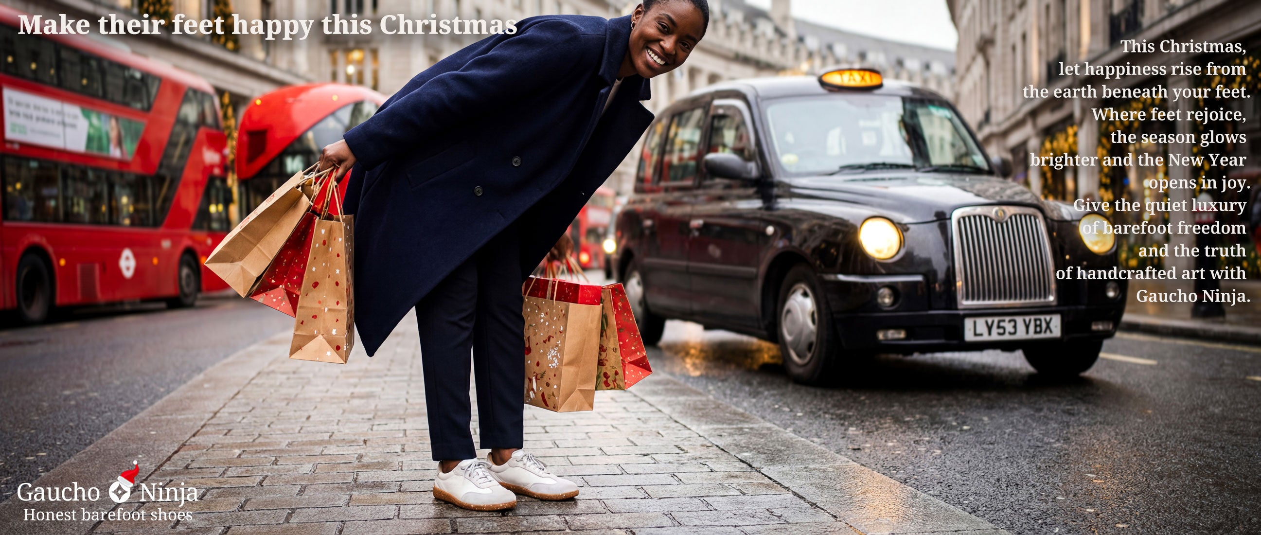 woman with Christmas shopping bags standing on a London street with a black taxi and red buses in the background wearing Gaucho Ninja barefoot trainers