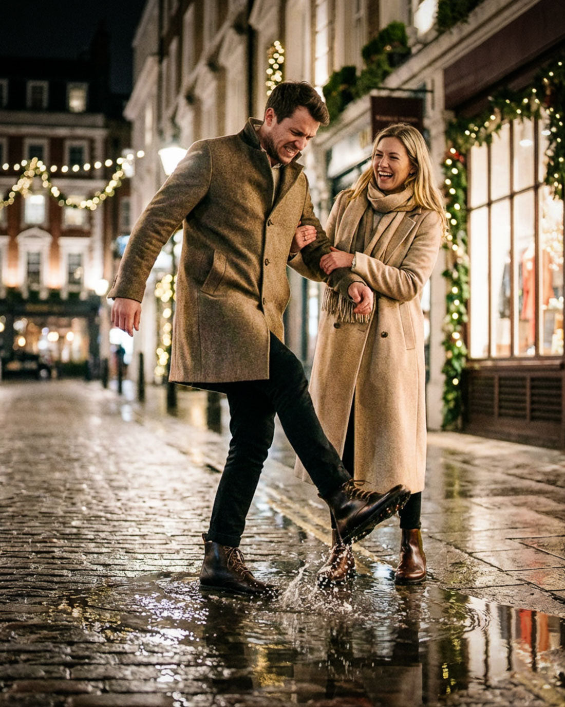 Man and woman wearing Gaucho Ninja barefoot boots in beige coats walking together on a wet street with Christmas decorations.