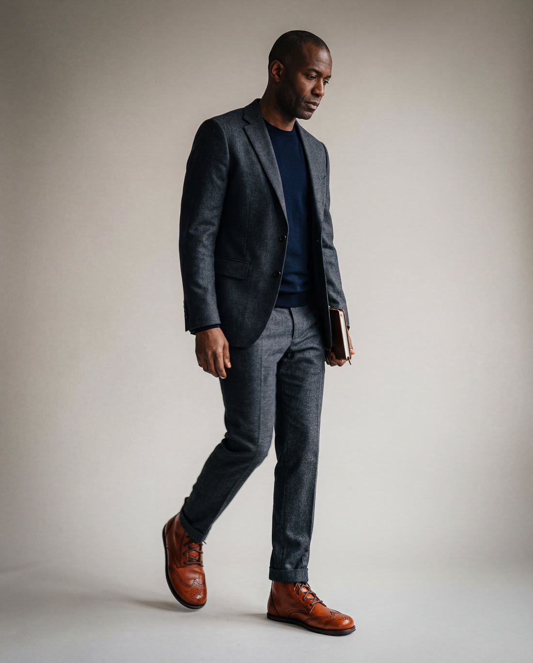 Man in a gray suit wearing brown Goodyear Welted barefoot Chukka Brogue boots